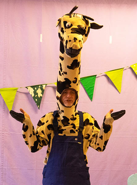 mark de schrijver van giraf heeft een echt giraffenpak aan, hij speelt de prentenboek figuur giraf