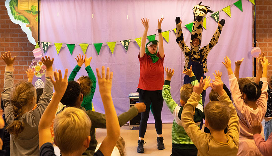 alle kinderen juichen mee met Giraf en Krook tijdens de voorstelling kinderboekenweek 2023